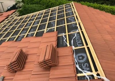 Tuiles terre cuite pos&eacute;es sur des liteaux au-dessus d'un &eacute;cran de sous-toiture, pose en cours