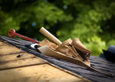 Ceinture &agrave; outils en cuir avec marteau pos&eacute;e sur des bardeaux de toiture