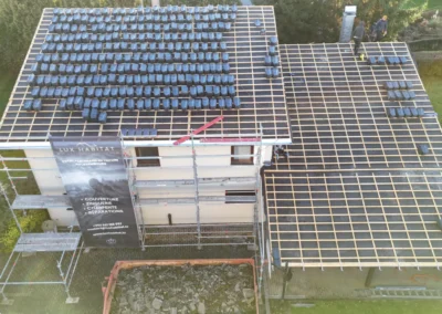Vue a&eacute;rienne d'une maison &eacute;chafaud&eacute;e avec b&acirc;che Lux Habitat et toiture latt&eacute;e couverte de paquets de tuiles