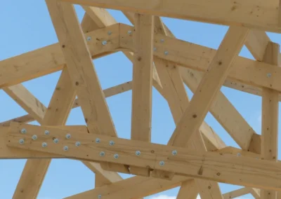 Gros plan sur l'assemblage d'une ferme de charpente en bois avec plaques et boulons m&eacute;talliques
