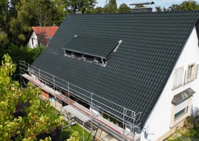 Vue a&eacute;rienne d'une maison blanche avec toiture neuve en tuiles anthracite et &eacute;chafaudage
