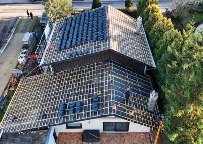 Vue a&eacute;rienne d'une maison individuelle dont la toiture est en cours de couverture avec des tuiles anthracite