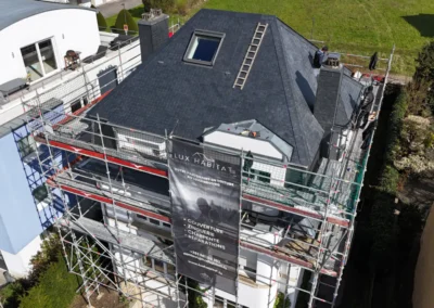 Vue a&eacute;rienne d'une r&eacute;sidence &eacute;chafaud&eacute;e avec toiture en ardoise, lucarne, &eacute;chelle de couvreur et b&acirc;che Lux Habitat
