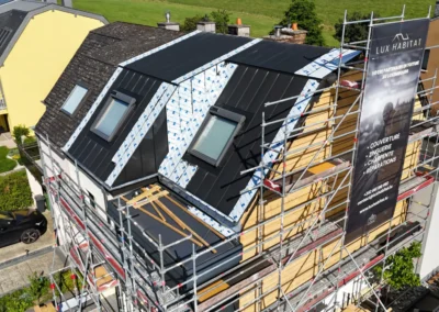 Vue par drone d'une maison mitoyenne &eacute;chafaud&eacute;e avec toiture &agrave; joint debout anthracite, deux fen&ecirc;tres de toit et b&acirc;che Lux Habitat