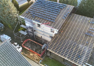 Vue par drone d'une toiture latt&eacute;e avec des paquets de tuiles anthracite r&eacute;partis sur les liteaux