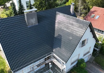 Vue a&eacute;rienne d'une toiture en tuiles anthracite neuve avec chemin&eacute;e habill&eacute;e, sur une maison individuelle