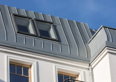 Toiture en zinc &agrave; joint debout avec lucarnes et fen&ecirc;tres, fa&ccedil;ade blanche